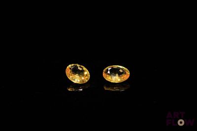 une paire de boucles d'oreilles en saphir jaune sur fond noir