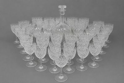 many wine glasses and a bottle sitting on a table