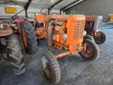 many old tractors parked in a garage together