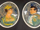 une paire de portraits en céramique représentant un homme et une femme