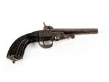 un vieux pistolet posé sur une surface blanche