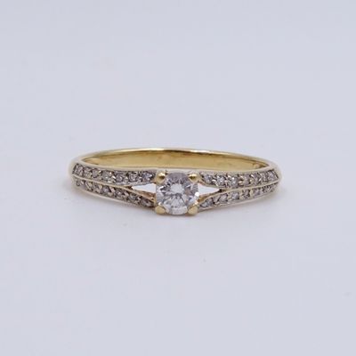une bague en or et diamants sertie d'une seule pierre