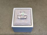 bague en argent massif sertie d'une pierre verte, présentée dans un coffret cadeau