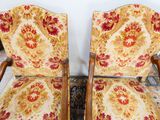 two wooden chairs with floral upholstered upholstered cushions