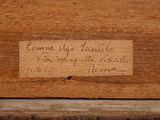 a label on a piece of wood with writing on it