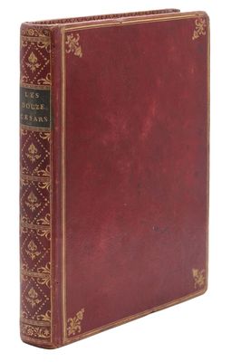 un vieux livre à la couverture rouge posé sur une surface blanche