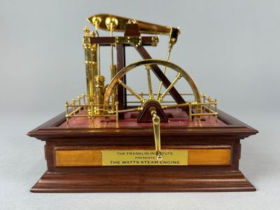 une maquette d'une machine à vapeur posée sur un socle en bois