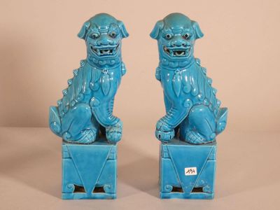 pair of blue foo foo dogs sitting on blue boxes on a white background