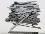 une règle posée à côté d'une pile de scies