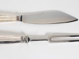 deux fourchettes et un couteau sur une table blanche