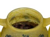 a yellow vase with blue flowers on it on a white surface