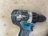 a close up of a cordless drill on a concrete floor