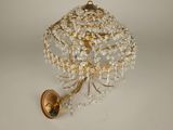 une applique murale dorée ornée d'une boule de cristal