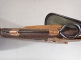 a brown case with a pair of scissors inside of it
