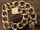 a gold chain bracelet with a padlock on top of it