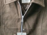 the back of a brown jacket with a label on it