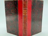 un vieux livre à la couverture rouge posé sur une table