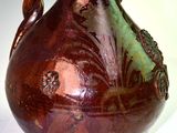 a brown vase with a handle sitting on a table