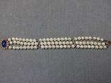 un gros plan sur un bracelet orné de perles et d'une pierre bleue