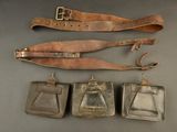 three antique leather purses and a leather belt on a table