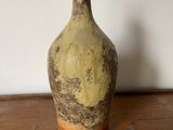 un vase marron et jaune posé sur une table en bois