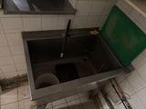 an image of a bathroom with a sink and a trash can