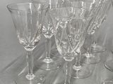 six wine glasses and a pitcher on a table