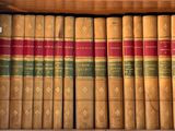 de nombreux livres anciens dans une boîte en bois posée sur l'étagère