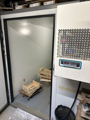 une pièce avec un réfrigérateur et un tas de bois par terre