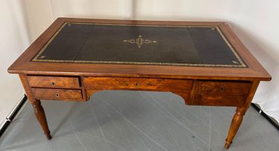 an antique writing desk with a leather top and drawers