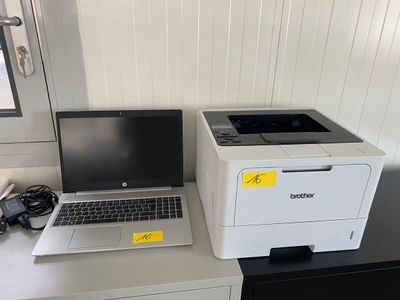 un ordinateur portable et une imprimante posés côte à côte sur un bureau