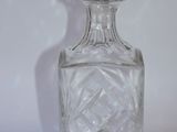 a clear glass bottle with a glass stopper on top of it