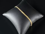 un coussin en cuir noir orné d'une chaîne dorée