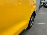 a close up of a yellow car parked in a parking lot