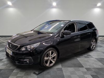 la voiture noire est garée sur un sol en damier dans le garage