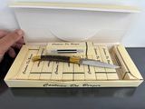 someone is holding a knife in a box on a table
