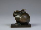 a bronze sculpture of a rabbit on a wooden base