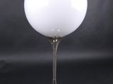 une photo d'une lampe de table sur laquelle est posée une boule en verre blanc