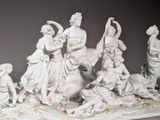 a statue of a group of people that are sitting on a table