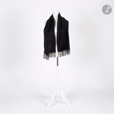 une écharpe noire posée sur un pied de mannequin, devant un fond blanc