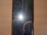 the back of a black phone sitting on top of a wooden table
