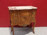 a small wooden chest of drawers with a marble top