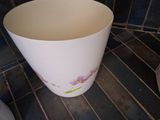 a white bowl sitting on a tiled floor next to a toilet