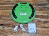 a green robot that is sitting on a wooden floor