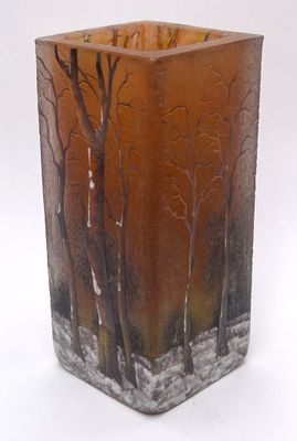 a glass vase with a picture of trees on it