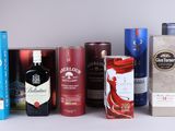many different types of alcohol bottles and boxes on the table