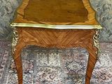 a small table with a wooden top on a rug