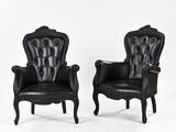 pair of black leather armchairs with carved arms and arms