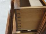 a wooden dresser with three drawers in it
