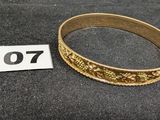 un gros plan d'un bracelet en or sur lequel figure un numéro
